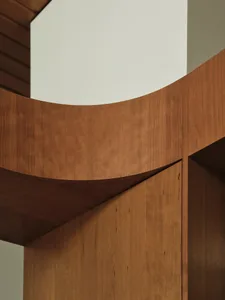 A modern interior design featuring wooden cabinets with curved edges.