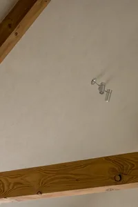 極簡室內空間，搭配紋理灰泥牆面與木樑
