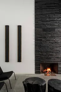 A modern black stone fireplace in a living room setting with seating.