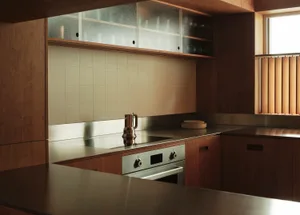 A modern kitchen with wooden countertops and tiled backsplash.