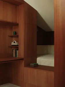 A minimalist office space featuring wood-paneled walls and a comfortable seating area with green upholstery.