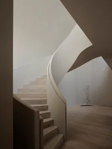 A modern, minimalist staircase with wooden steps and railings.