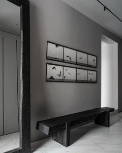 Industrial-style interior design featuring a wooden bench with black and white photography of birds on the wall.