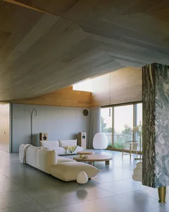 A minimalist living room featuring concrete furniture and wooden accents.
