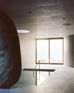A minimalist swimming pool interior made of concrete, featuring sleek lines and a modern design.