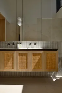 Modern bathroom with wooden cabinets and light fixtures.