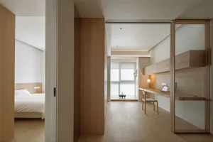 A modern minimalist bedroom featuring wooden elements and a clean, spacious design.