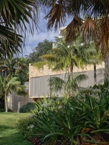 Modern residential exterior with stone walls and metal accents.