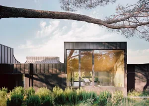 Modern residential exterior featuring wooden shingles and large windows.