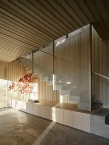 A modern staircase featuring perforated metal risers, concrete treads, and wood accents alongside a minimalist interior desig