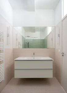 Modern minimalist bathroom with ceramic tile walls and metallic accents.