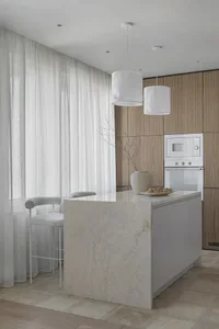 White minimalist kitchen with marble countertop and wooden cabinets, featuring a stylish hanging lamp and a modern bar stool.
