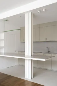 A minimalist white kitchen featuring metallic countertops.