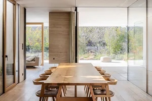 Modern dining room featuring a rectangular wooden table surrounded by matching chairs in a minimalist interior design.