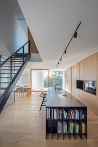 Modern kitchen dining space featuring wood and concrete materials with a minimalist design.