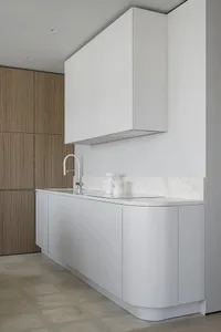Minimalist kitchen with white cabinets and marble countertops
