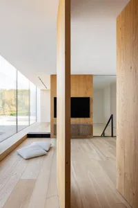 A modern minimalist living room with wooden walls and a television mounted on the wall.
