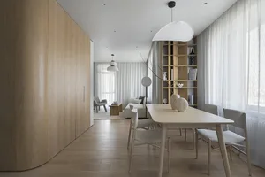 A minimalistic living room with wooden furnishings and light-colored curtains.