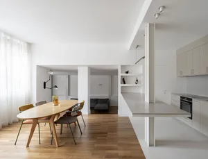 A modern residential kitchen with white cabinets and minimalist design features.