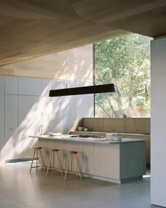Modern residential kitchen featuring wood cabinets and a large island.