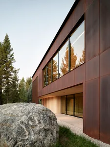 Modern residential exterior featuring metal cladding and large windows.