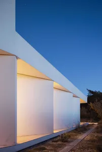 A modern house with a white exterior and concrete finish.