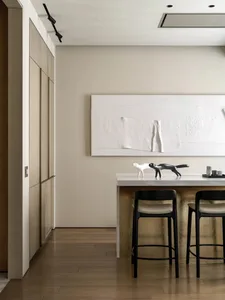 Minimalist interior design with white walls, wooden flooring, minimalist furniture, and a large white rectangular art piece o