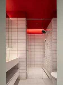 Modern bathroom with red ceiling and white tiled walls.