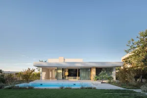 A modern house with a concrete exterior and a swimming pool in the backyard.
