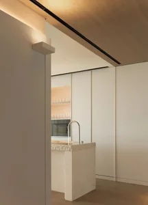 A modern kitchen featuring concrete countertops and minimalist design.