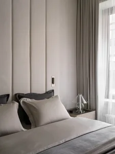 Minimalist bedroom with a bed, pillows, and a glass table lamp.