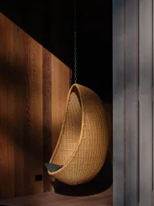 A cozy hanging chair made of wicker in a warm, comforting space.