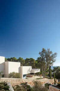 Modern house with stone wall, glass windows, and metal accents.