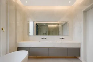 A modern bathroom interior with marble walls and a floating vanity.