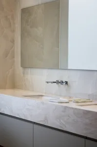 A modern bathroom featuring a marble countertop and sink with a minimalist design.