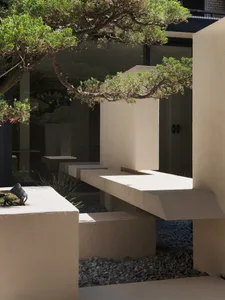 Concrete seating and landscaping elements in a modern architectural entryway.