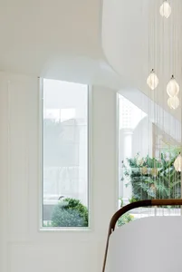 A modern interior space featuring a large window with a view of greenery outside.