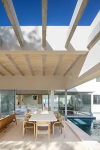 Modern living room with glass walls overlooking a pool.