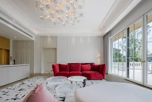 Modern living room featuring a contemporary red sofa, glass tables, and a large glass door.