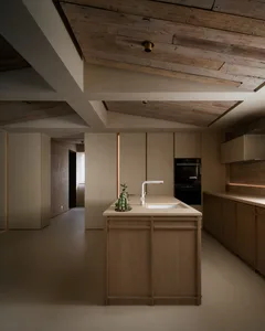 A modern minimalist kitchen with wooden cabinets and a central island.