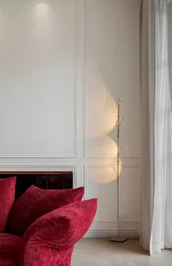 Modern living room with a red velvet sofa and stylish floor lamp.