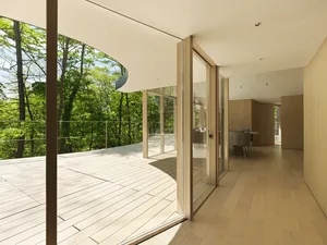 A modern residential deck featuring wood flooring and glass railings.
