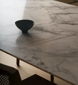 Marble table with a black bowl on it, photographed in a minimalist setting.