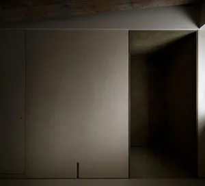A minimalist concrete interior with a door leading to another space.