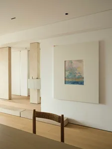 A minimalist interior design featuring a framed abstract painting.