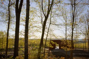 Modern outdoor architectural space with wooden structures, glass panels, and concrete floors.