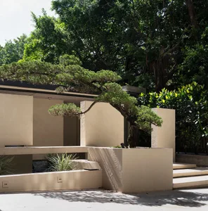 Modern residential house exterior with concrete walls and greenery.