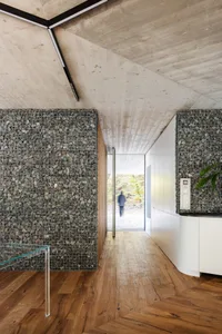 A modern interior featuring concrete walls and wooden flooring.