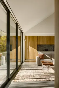 A modern interior with wooden walls, concrete flooring, and glass windows.