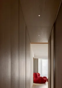 A modern interior space with wooden paneling and red furniture.